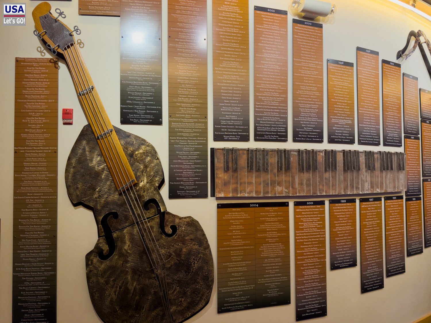 &Uuml;berdimensionaler Kontrabass und Konzertdatum-Tafeln in der Ausstellung des Red Rocks Visitor Center